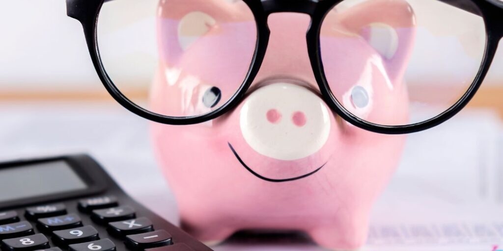 Get Your Affairs in Order - an image of a pink piggie bank with black glasses next to a black calculator